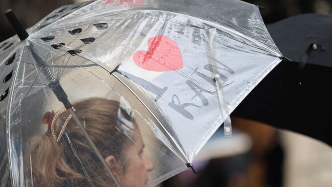 Una mujer se refugia de la lluvia en una calle de Málaga.