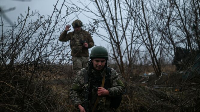 Soldados ucranianos caminan entre un sistema de zanjas.