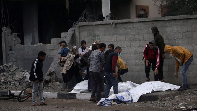 Un grupo de palestinos ayuda a rescatar cuerpos de los escombros de una vivienda en Deir Al Balah.