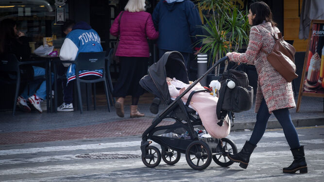 Una mujer empuja el carrito de su bebé, en una céntrica calle de la ciudad.