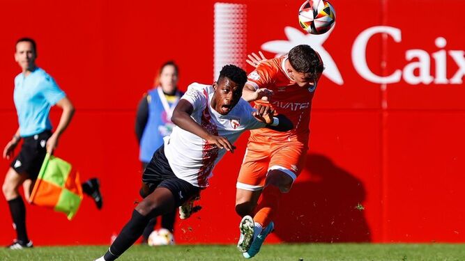 Bakary intenta anticiparse de cabeza a su par en el Sevilla Atlético-Vélez.