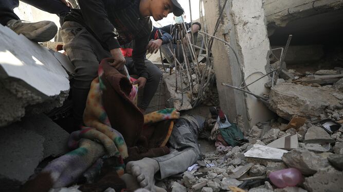 El cuerpo de un hombre yace entre los escombros de una vivienda tras un bombardeo contra Al Maghazi.
