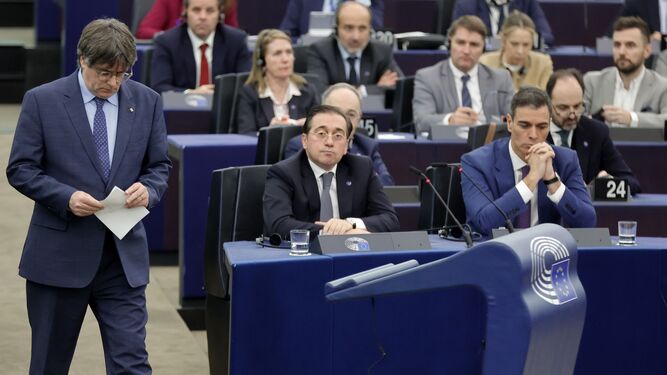 Carles Puigdemont se aproxima a la tribuna de oradores de la Eurocámara y pasa junto al ministro de Asuntos Exteriores, José Manuel Albares, y el presidente del Gobierno, Pedro Sánchez.