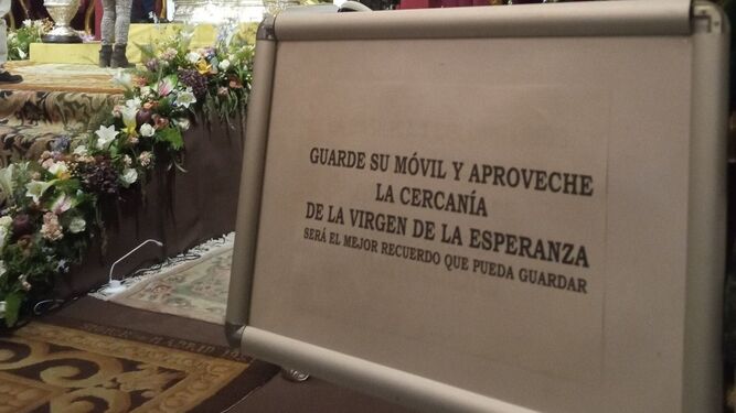 El cartel que recomienda que no se use el móvil en el besamano de la Virgen de la Esperanza de Málaga.