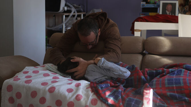 Uno de los niños en régimen de hospitalización domiciliaria junto a su padre.