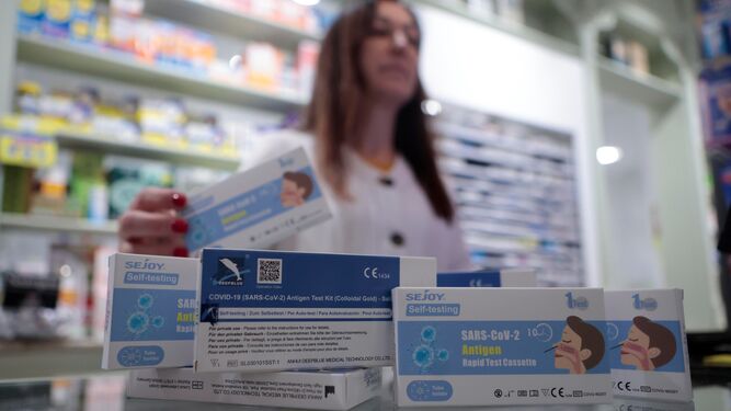 La farmacéutica de la farmacia Santa Ana en Triana muestra test de gripe y Covid.