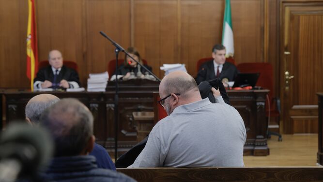 Juan Francisco Trujillo, de espaldas a la cámara, frente al tribunal de la Sección Primera de la Audiencia de Sevilla durante la primera sesión del juicio, celebrada este lunes.