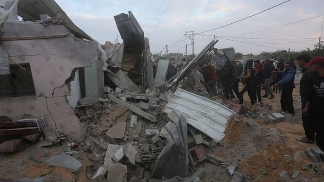 Un grupo de personas rodean una vivienda destrozada por un ataque israelí en el sur de la Franja de Gaza.