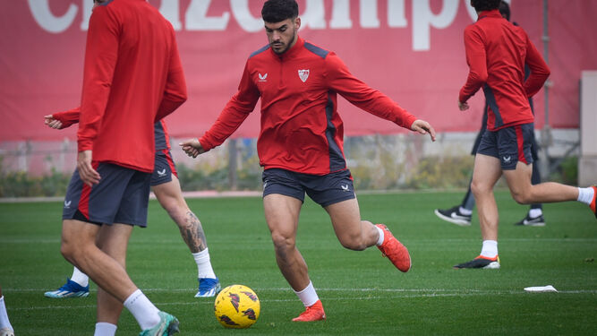 Isaac conduce el balón en la ciudad deportiva del Sevilla.