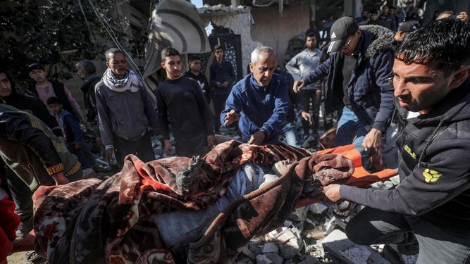Palestinos recuperan un cuerpo entre los escombros de una casa destruida por los bombardeos en Deir al Balah.