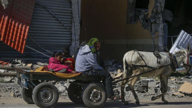 Una familia palestina se desplaza en un carro tirado por un burro en el campo de refugiados de Al Nusairat.