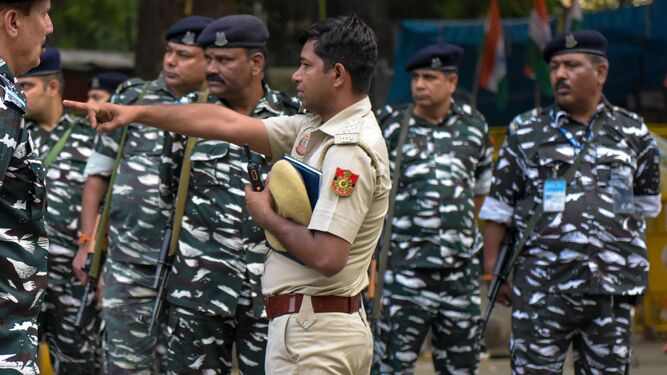 Un policía da instrucciones a unos soldados en la India.