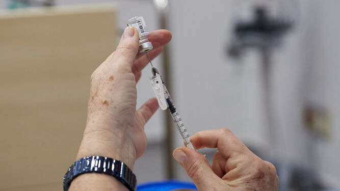 Una sanitaria sostiene el material necesario para la aplicación de una la vacuna.