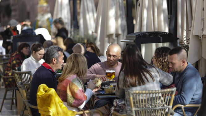 Varias personas comiendo y bebiendo en la terraza de un negocio de hostelería, en una imagen de archivo.