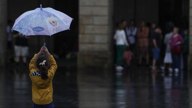 Imagen de archivo de una niña con un paraguas.