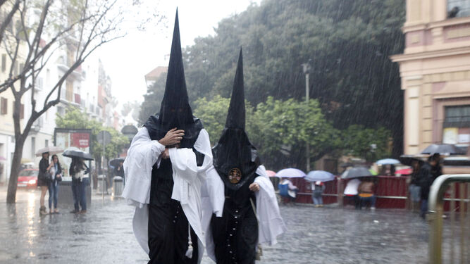 Dos nazarenos del Museo bajo la lluvia.