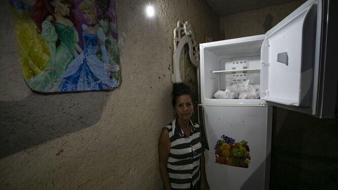 Una mujer muestra la nevera de su casa en Santa Ana, cerca de Varadero, en Cuba.