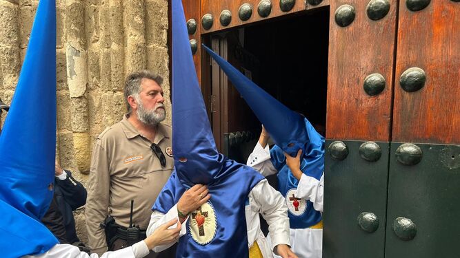 Los nazarenos de la HIniesta abandonan San Julián tras anularse su salida en el Domingo de Ramos de Sevilla 2024.