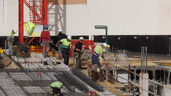Varios obreros trabajan en la construcción de un edificio de pisos.