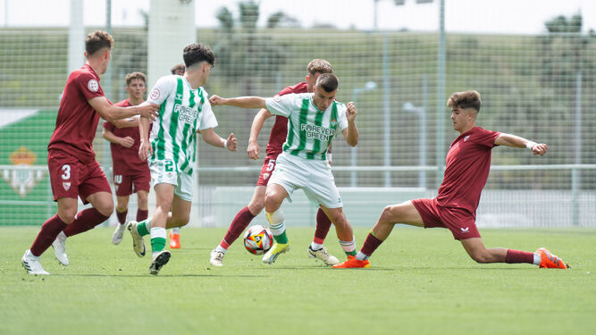 El delantero bético Pablo García intenta llevarse un balón ante el sevillista Nacho.
