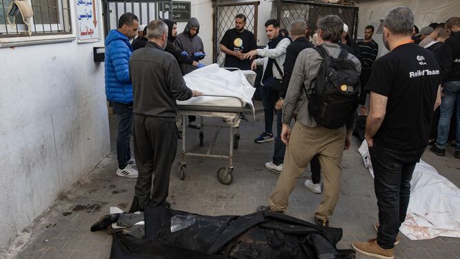 Trabajadores de la ONG  World Central Kitchen rodean los cuerpos de sus compañeros asesinados en Gaza.