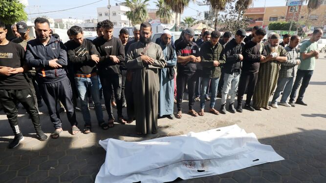 Palestinos rezan ante los cuerpos de familiares fallecidos.