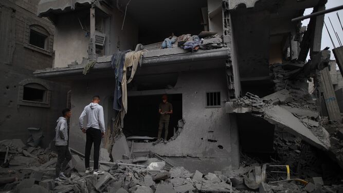 Varios palestinos revisan los daños en una vivienda en el campo de refugiados de Maghazi.
