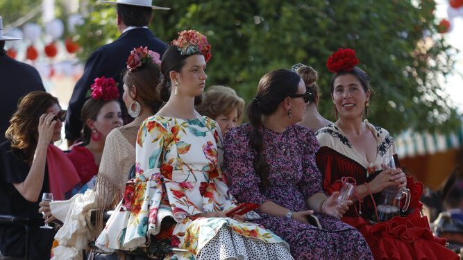 Jóvenes vestidas de flamenca en el Paseo de Caballos.